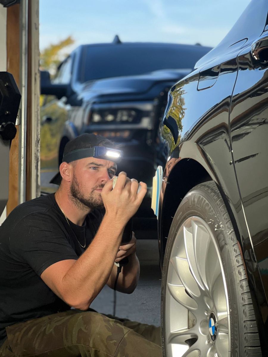 Austin Trigg inspecting a wheel with a flashlight