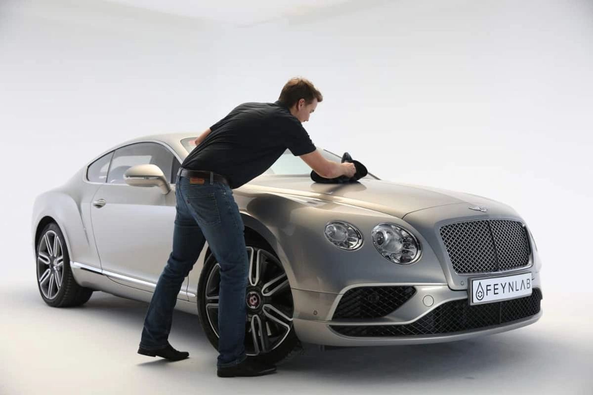 Technician applying a FEYNLAB ceramic coating to a silver Bentley Continental