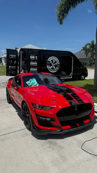 Red Ford Mustang Shelby GT500 in front of the open Outlaw Detailing mobile van, ceramic coating client in Sarasota