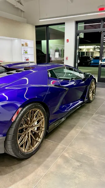 Side view of a purple Lamborghini Revuelto with bronze wheels in the Lamborghini Sarasota showroom