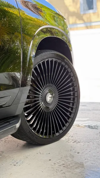Close-up of a clean black SUV wheel and glossy fender