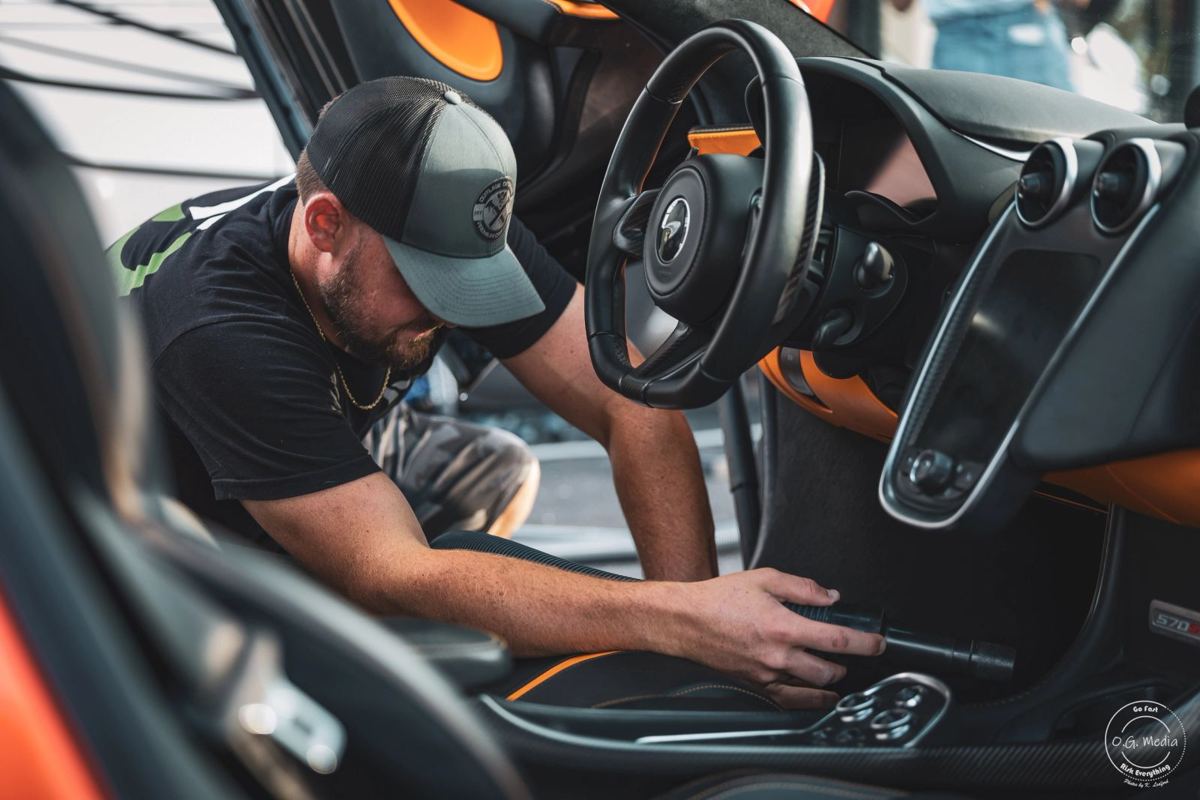 Detailer cleaning the interior of a McLaren